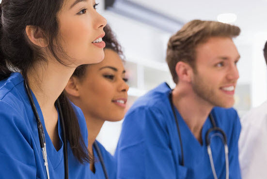 trainees in scrubs looking ahead